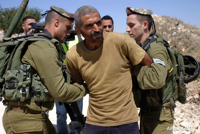 Israeli soldiers scuffle with Palestinian, Israeli and foreign activists during a demonstration against the cof farm land to be used in the construction of Jewish settlements near the existing Israeli settlement of Karmi...