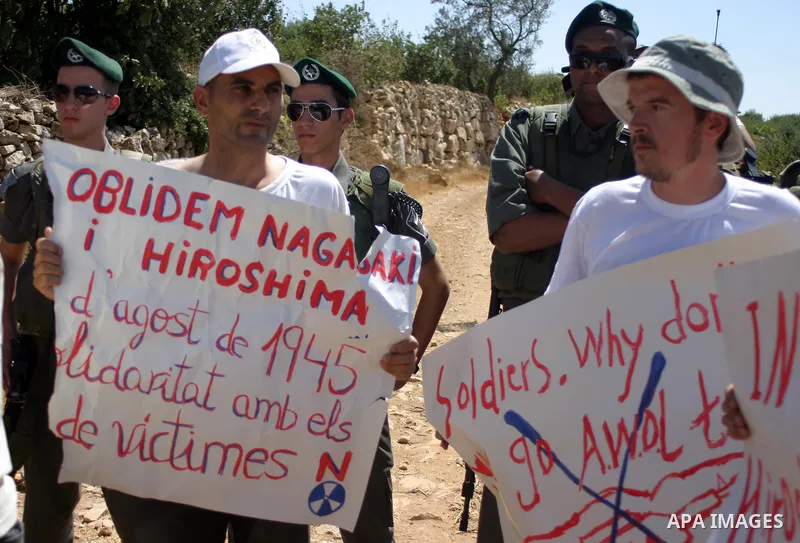 Israeli soldiers scuffle with Palestinian, Israeli and foreign activists during a demonstration against the cof farm land to be used in the construction of Jewish settlements near the existing Israeli settlement of Karmi...