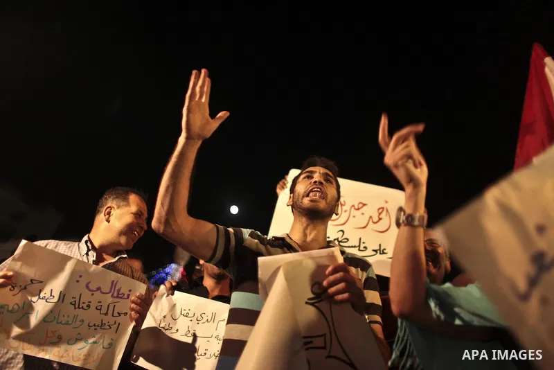 Palestinians hold Syrian flags as they join a demonstration in the West Bank city of Ramallah on Aug. 14, 2011 in support of the Syrian opposition . At least 23 people were killed 14 August when the Syrian army attacked...