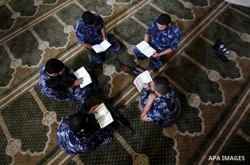 Palestinian members of Hamas security read a copy of the holy Koran in a Mosque during the holy month of Ramadan in Gaza Strip on 14 August 2011. Muslims around the world are observing the holy fasting month of Ramadan i...