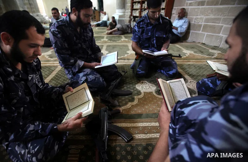 Palestinian members of Hamas security read a copy of the holy Koran in a Mosque during the holy month of Ramadan in Gaza Strip on 14 August 2011. Muslims around the world are observing the holy fasting month of Ramadan i...