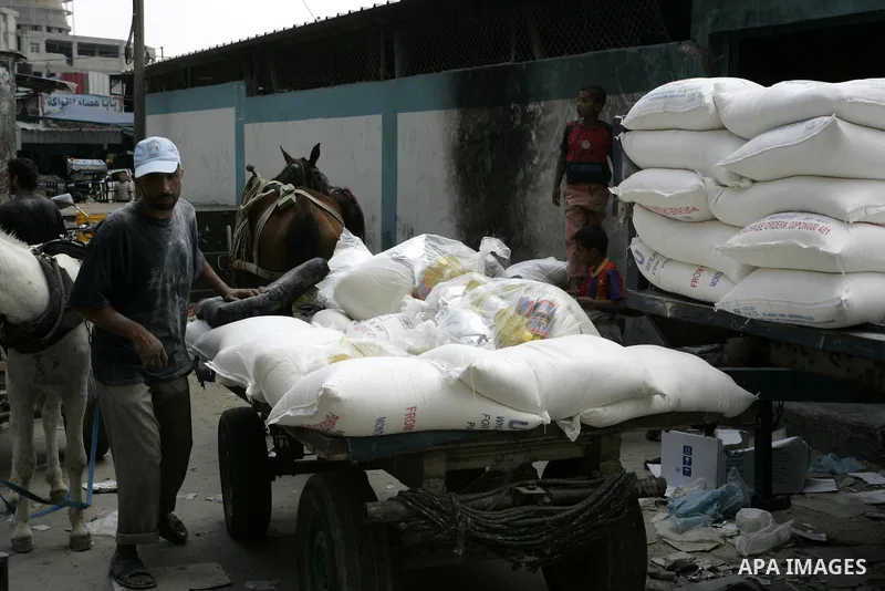 Palestinians receive food aids from the United Nations Relief and Works Agency (UNRWA) at the Rafah refugee camp, in the southern Gaza Strip on August 15, 2011. USAID halted humanitarian assistance to the Gaza Strip over...