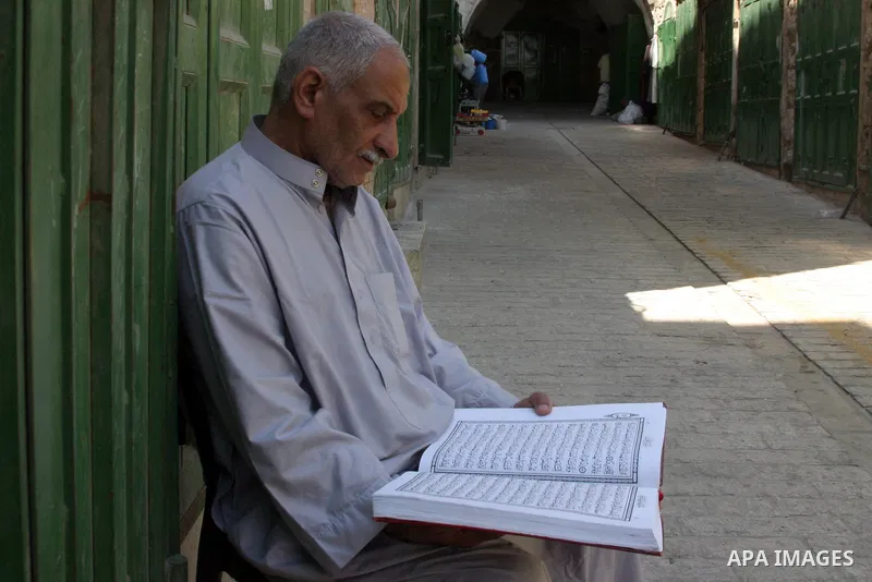 A Palestinian vendor reads the holy koran infront of his shop in the West Bank city of Hebron on Aug. 15, 2011. Muslims around the world abstain from eating, drinking and conducting sexual relations from sunrise to sunse...