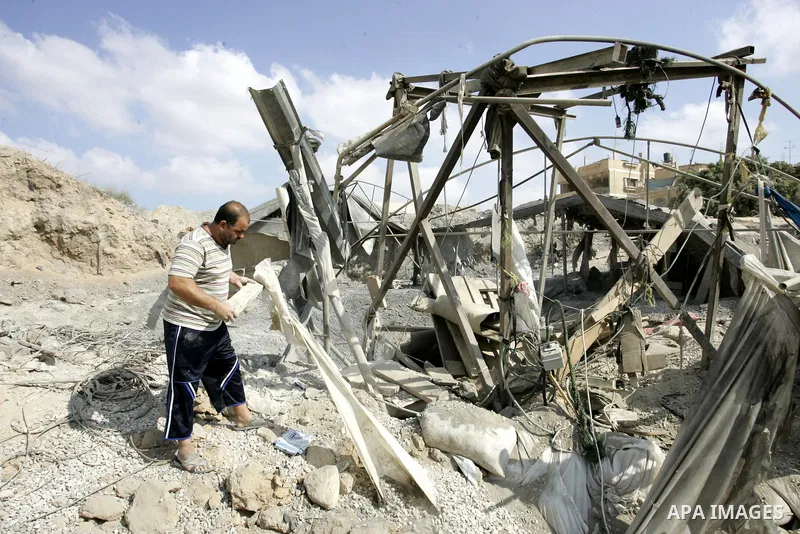 Palestinians inspect the damage outside a smuggling tunnel following an overnight Israeli airstrike in Rafah, on the border between Egypt and southern Gaza Strip, Tuesday on Aug. 16, 2011. after one Palestinian was kille...