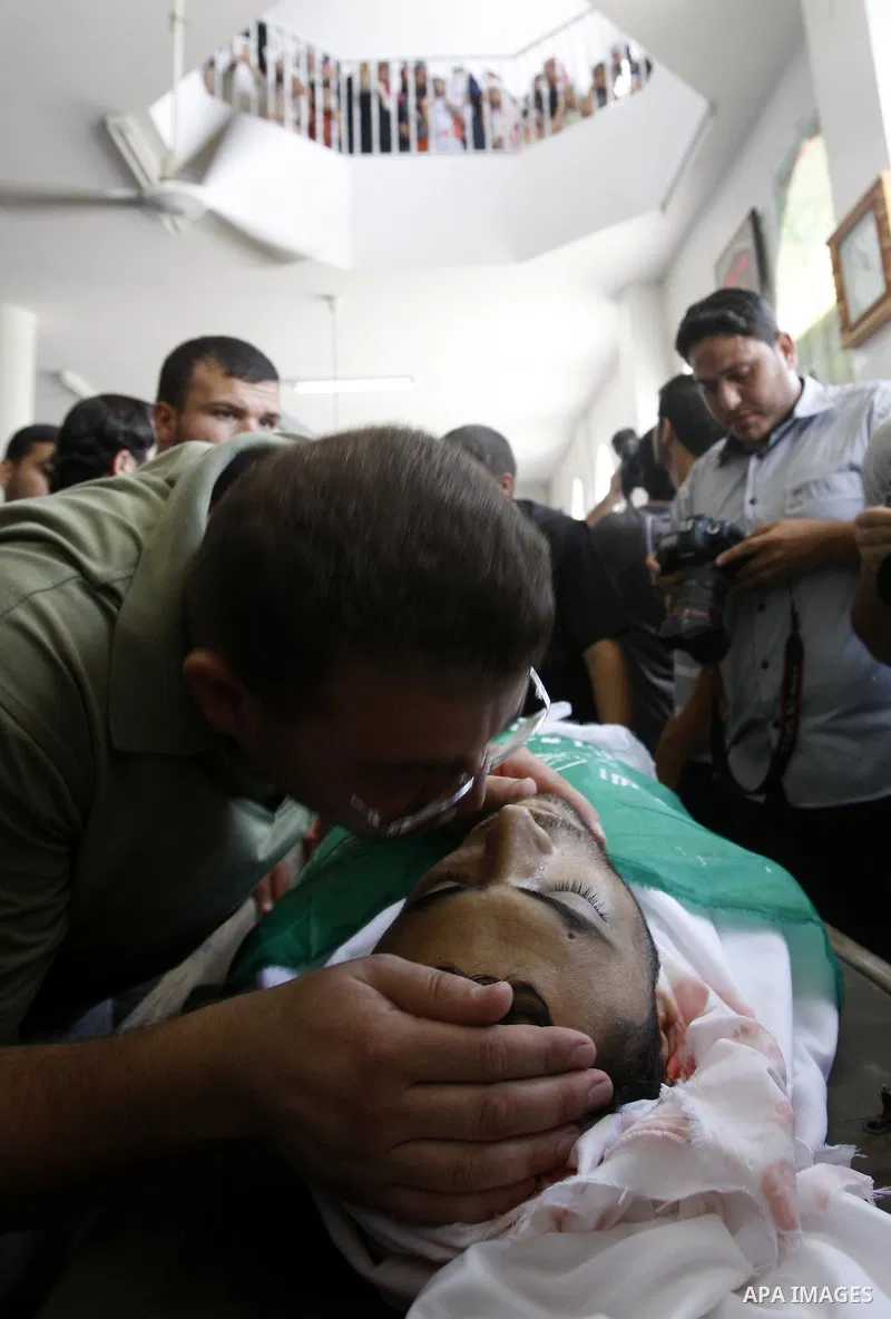 Palestinian relatives of Moussa Shtewi, 29, kiss during his funeral in Gaza City, Tuesday, Aug. 16, 2011. Israeli aircraft struck five targets in the Hamas-ruled Gaza Strip on Tuesday, killing Sh'tehwi and wounding four...