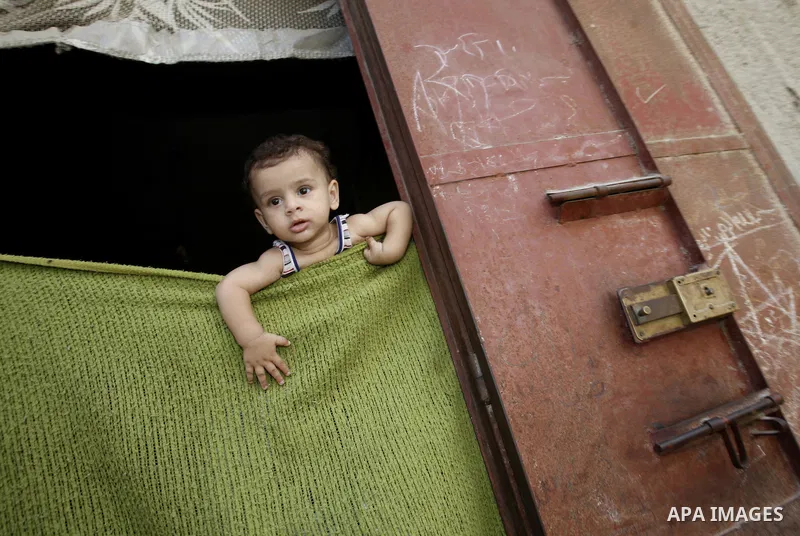 A Palestinian child looks at the funeral of Moussa Shtawe inside his home in Gaza City on Aug. 16, 2011 after he was killed and seven injured by overnight Israeli air strikes across the Gaza Strip, Palestinian medics sai...