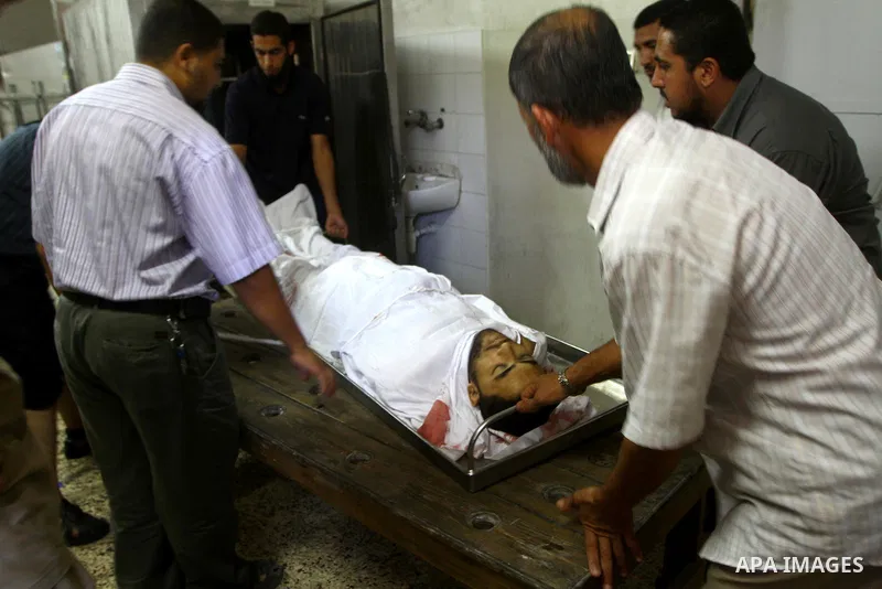 Palestinian relatives stand next to the body of Hamas militant Moussa Shtewi, 29, at the morgue in a hospital in Gaza City, Tuesday, on Aug. 16, 2011. Israeli aircraft struck five targets in the Hamas-ruled Gaza Strip on...