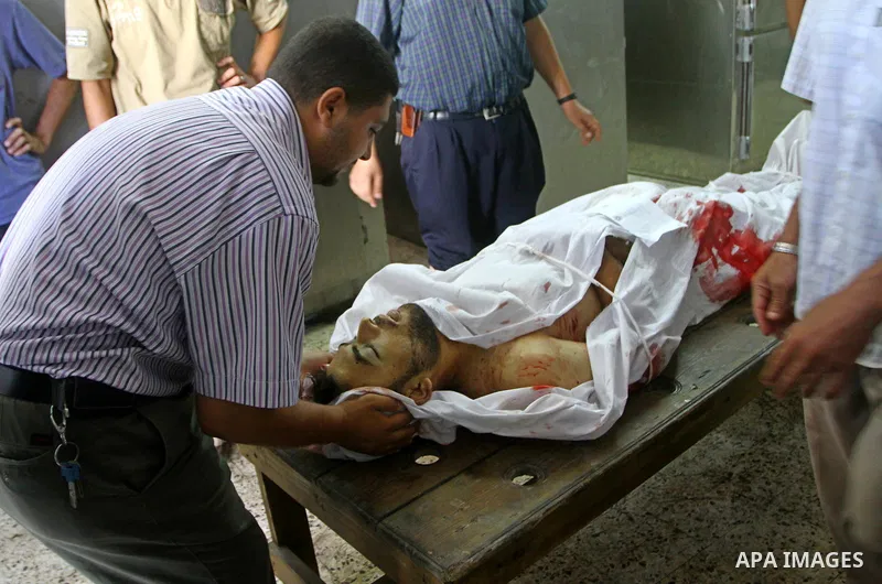 Palestinian relatives stand next to the body of Hamas militant Moussa Shtewi, 29, at the morgue in a hospital in Gaza City, Tuesday, on Aug. 16, 2011. Israeli aircraft struck five targets in the Hamas-ruled Gaza Strip on...