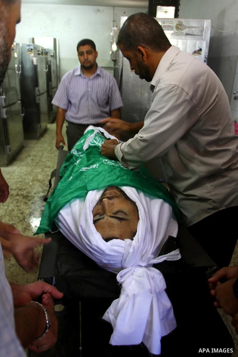 Palestinian relatives stand next to the body of Hamas militant Moussa Shtewi, 29, at the morgue in a hospital in Gaza City, Tuesday, on Aug. 16, 2011. Israeli aircraft struck five targets in the Hamas-ruled Gaza Strip on...