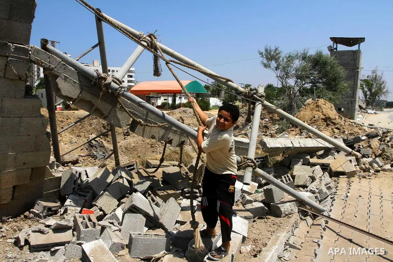 Palestinian children stand at the site of an Israeli air strike in Gaza City on August 16, 2011 after one Palestinian was killed and seven injured by overnight Israeli air strikes across the Gaza Strip, Palestinian medic...