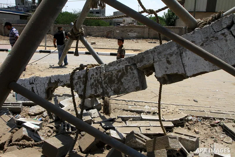 Palestinian children stand at the site of an Israeli air strike in Gaza City on August 16, 2011 after one Palestinian was killed and seven injured by overnight Israeli air strikes across the Gaza Strip, Palestinian medic...