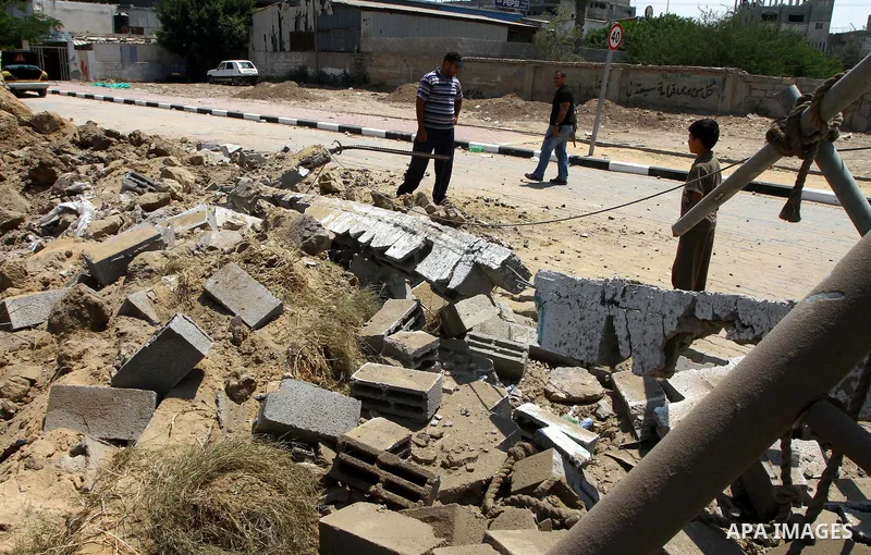 Palestinian children stand at the site of an Israeli air strike in Gaza City on August 16, 2011 after one Palestinian was killed and seven injured by overnight Israeli air strikes across the Gaza Strip, Palestinian medic...