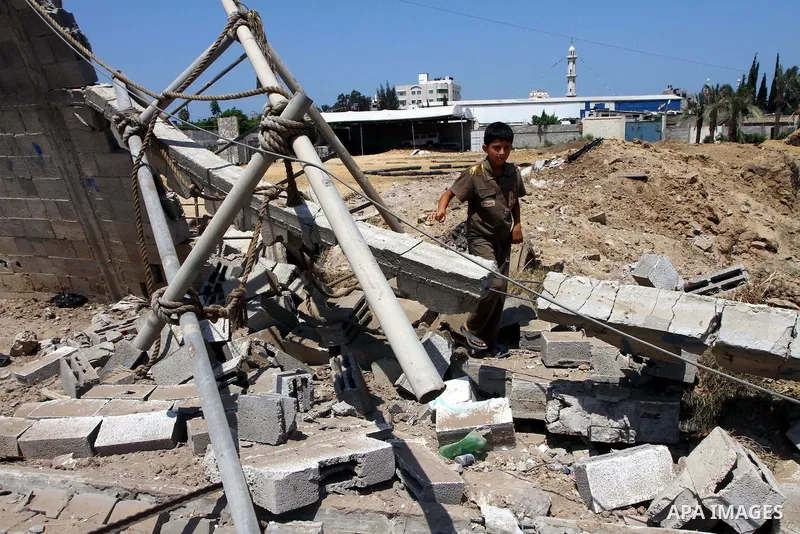 Palestinian children stand at the site of an Israeli air strike in Gaza City on August 16, 2011 after one Palestinian was killed and seven injured by overnight Israeli air strikes across the Gaza Strip, Palestinian medic...