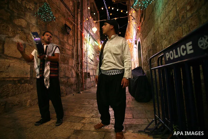 Palestinian youths use a traditional drum to wake up people for their Suhoor in a narrow street leading to the al-Aqsa Mosque in Jerusalem's Old City on August 16,2011, during the sixteenth day of the Muslim holy month o...