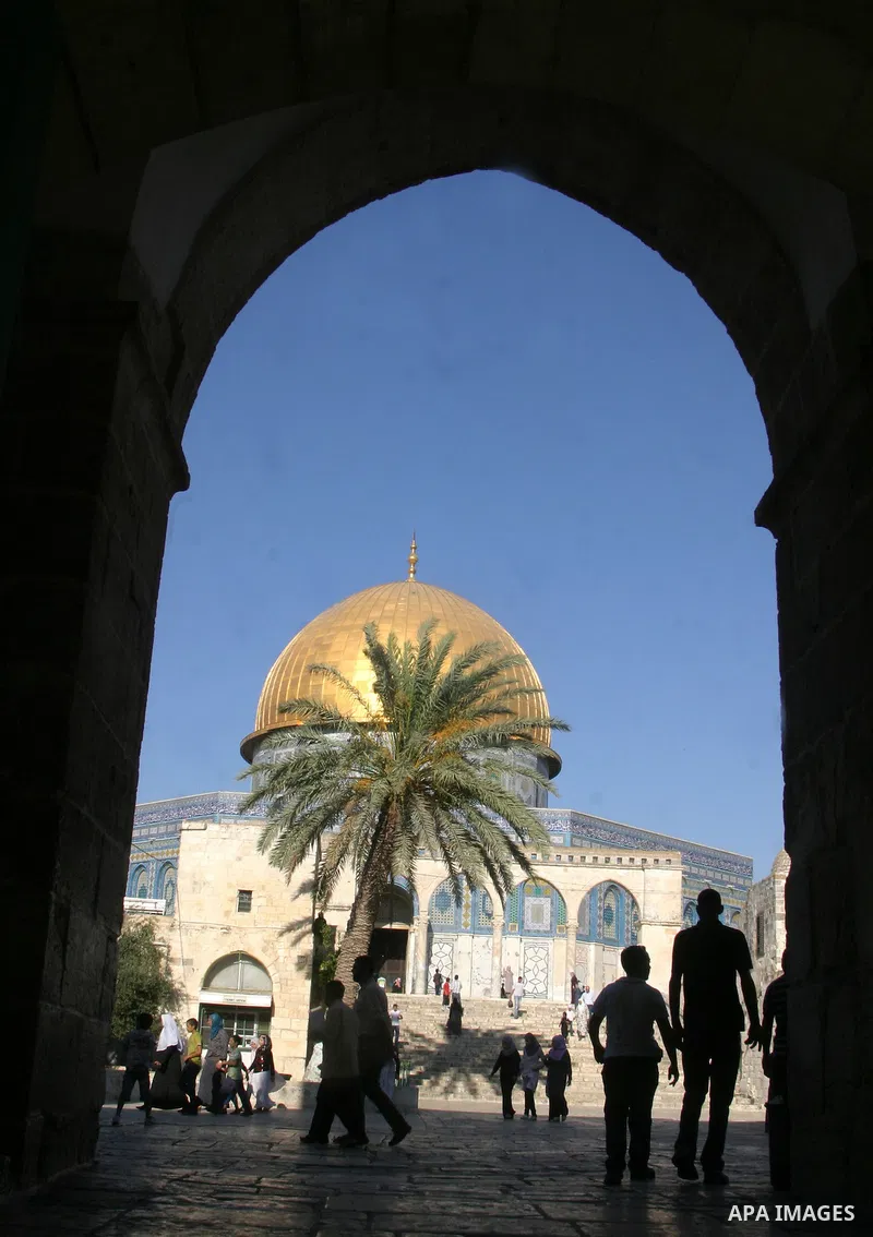 Palestinians walk in front of the Dome of the Rock at the al-Aqsa Mosque compound in Jerusalem's Old City on August 16,2011, during the sixteenth day of the Muslim holy month of Ramadan. Photo by Mahfouz Abu Turk