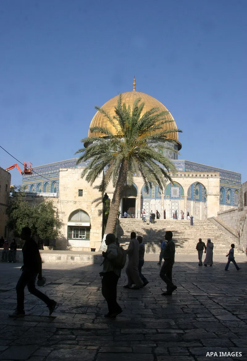 Palestinians walk in front of the Dome of the Rock at the al-Aqsa Mosque compound in Jerusalem's Old City on August 16,2011, during the sixteenth day of the Muslim holy month of Ramadan. Photo by Mahfouz Abu Turk