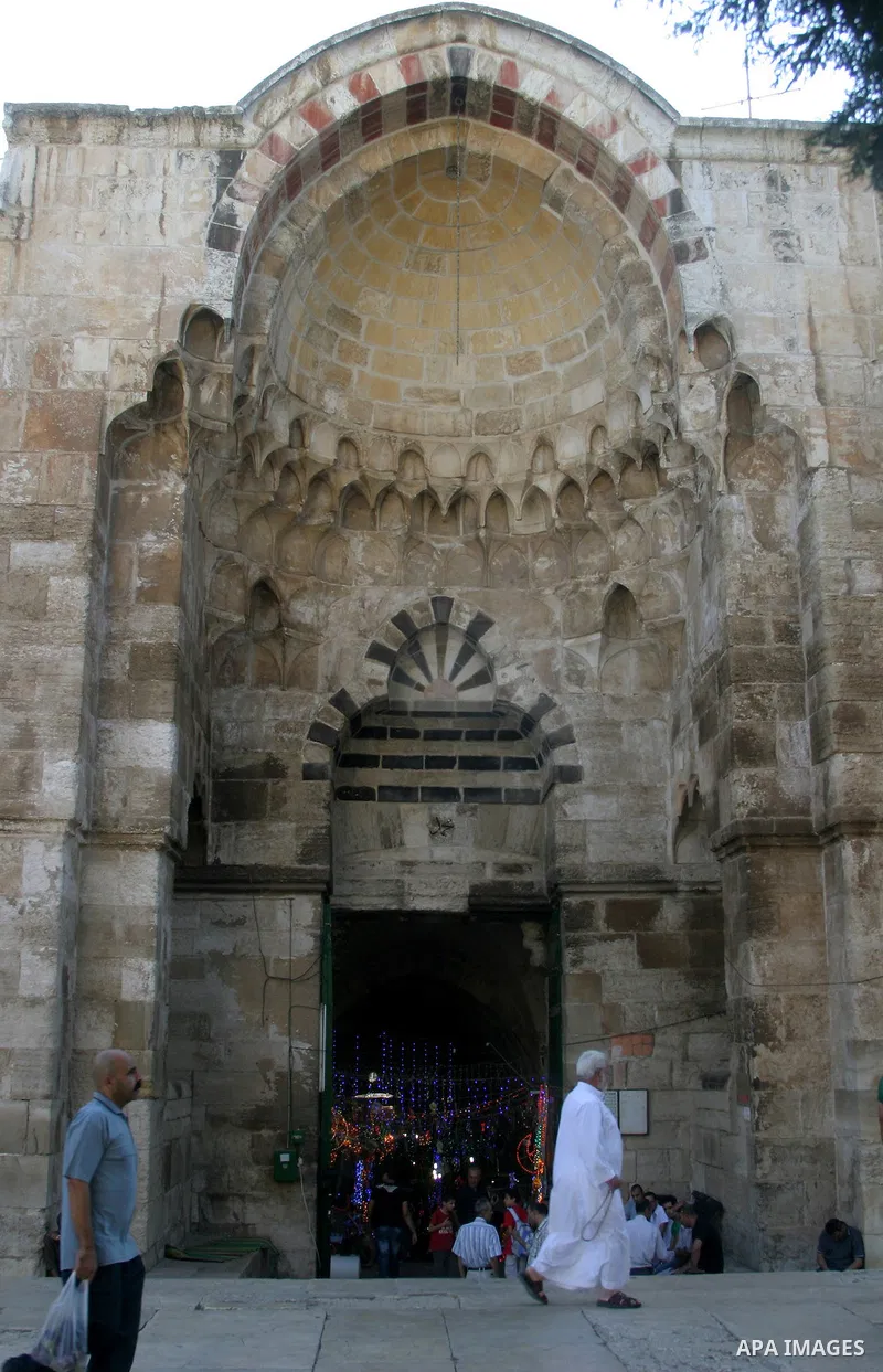 Palestinians walk in front of a gate of the main market Jerusalem's Old City on August 16,2011, during the sixteenth day of the Muslim holy month of Ramadan. Photo by Mahfouz Abu Turk