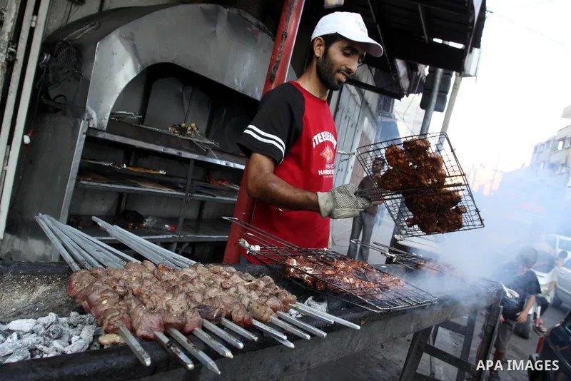 A Palestinian vendor prepares grilled meat "kebabs" and chicken at his shop in Gaza City on Aug. 16, 2011. Muslims around the world abstain from eating, drinking and conducting sexual relations from sunrise to sunset dur...