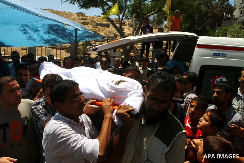 Palestinian mourners carry the body of Saed al Majdalawa during his funeral in the central Gaza Strip refugee camp of Nusseirat on August 17, 2011 a day after Israeli troops shot and killed him as he came near to the bor...
