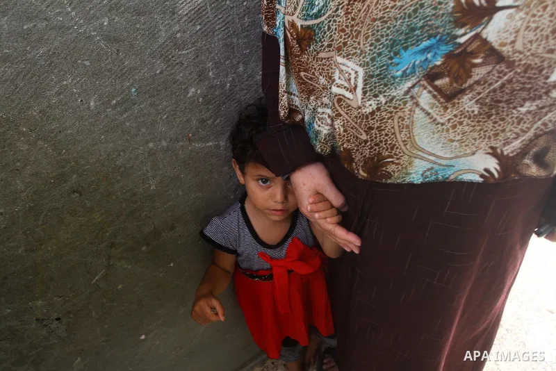 Palestinian girl stands with her mother during the funeral of Saed al Majdalawai in Nusseirat refugee camp in the central Gaza Strip on August 17, 2011. Israeli forces shot dead al Majdalawai near the border fence with I...