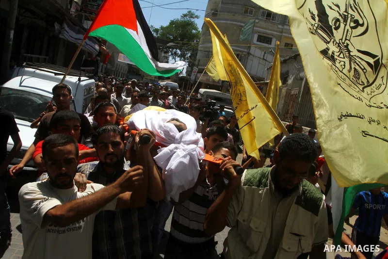 Palestinian mourners carry the body of Saed al Majdalawa during his funeral in the central Gaza Strip refugee camp of Nusseirat on August 17, 2011 a day after Israeli troops shot and killed him as he came near to the bor...
