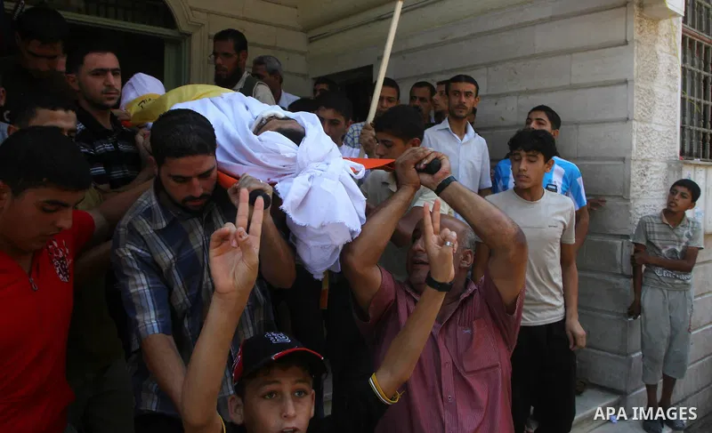Palestinian mourners carry the body of Saed al Majdalawa during his funeral in the central Gaza Strip refugee camp of Nusseirat on August 17, 2011 a day after Israeli troops shot and killed him as he came near to the bor...