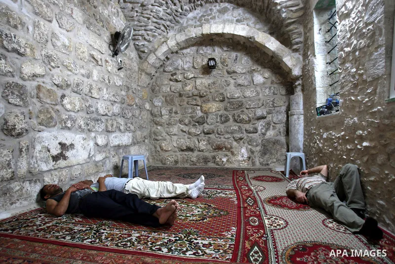 Palestinian Muslims rest as others pray and read the holy Koran at a Mosque during the holy month of Ramadan in the West Bank city of Nablus on Aug. 17, 2011. Muslims around the world are observing the holy fasting month...