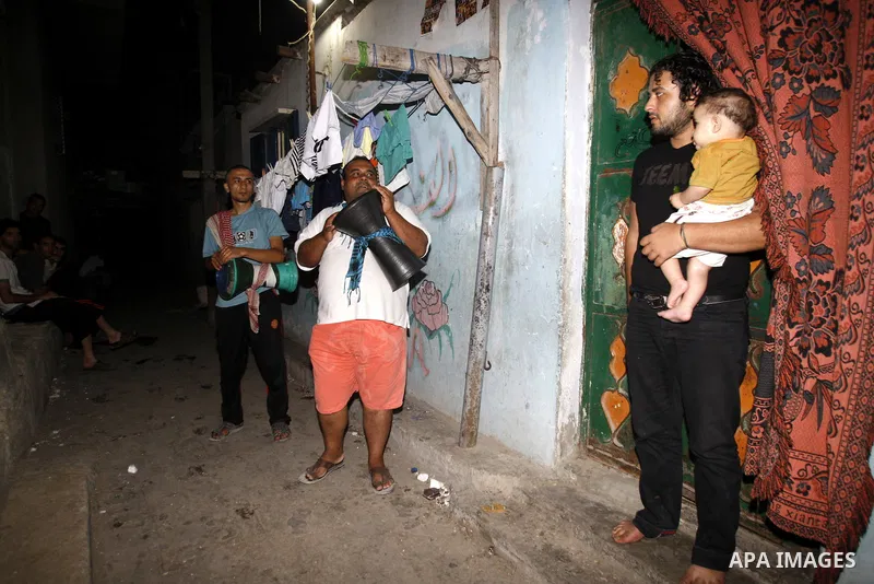 Palestinian youths use a traditional drum to wake up people for their Suhoor in a narrow street in Gaza city on August 16, 2011, during the sixteenth day of the Muslim holy month of Ramadan. Photo by Mahmud Nassar