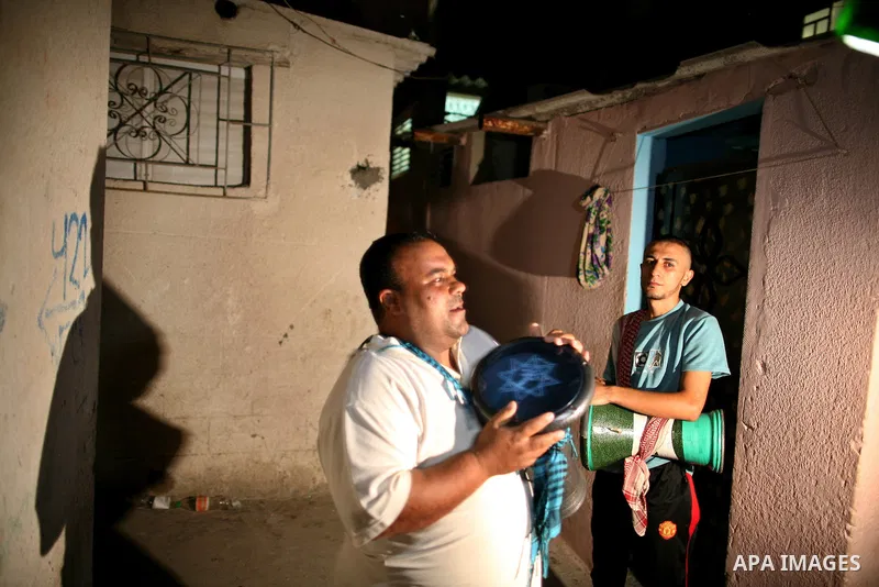 Palestinian youths use a traditional drum to wake up people for their Suhoor in a narrow street in Gaza city on August 16, 2011, during the sixteenth day of the Muslim holy month of Ramadan. Photo by Mahmud Nassar