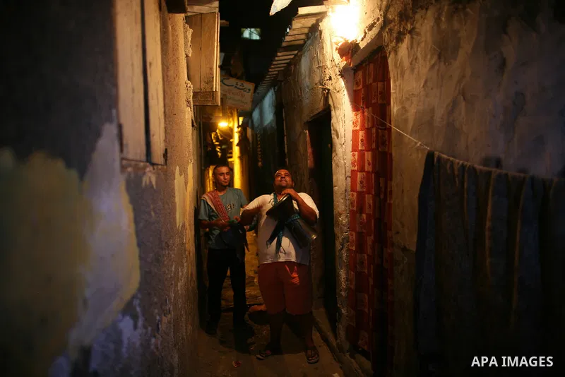 Palestinian youths use a traditional drum to wake up people for their Suhoor in a narrow street in Gaza city on August 16, 2011, during the sixteenth day of the Muslim holy month of Ramadan. Photo by Mahmud Nassar