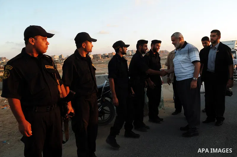 Palestinian Prime Minister in Gaza Strip, Ismail Haniya shakes hands with Hamas police during participating with them the meal of "Iftar" , during the seventeenth day of the holiest month of Ramadan in Gaza City on Aug....