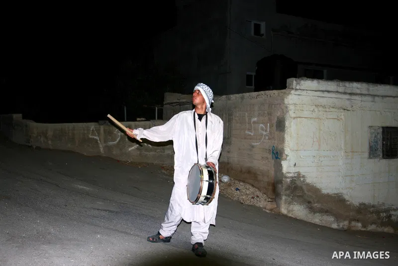A Palestinian man 'Mesaharaty' uses a traditional drum to wake up people for their Suhoor, in the village of Balata in the West Bank city of Nablus, on, Aug .18, 2011. Muslims throughout the world are celebrating the hol...