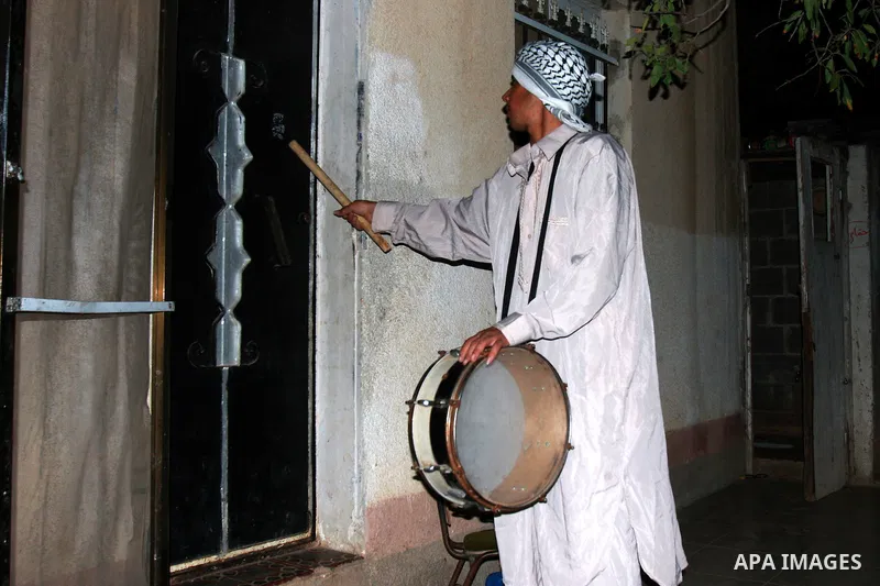 A Palestinian man 'Mesaharaty' uses a traditional drum to wake up people for their Suhoor, in the village of Balata in the West Bank city of Nablus, on, Aug .18, 2011. Muslims throughout the world are celebrating the hol...