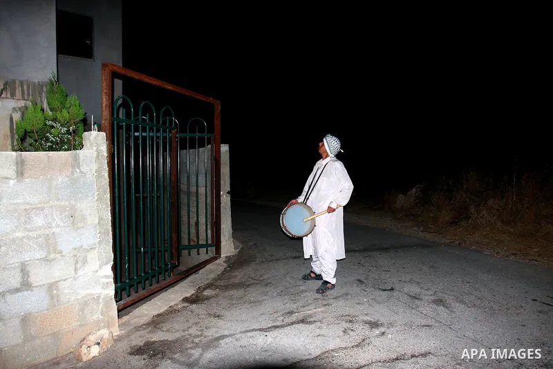 A Palestinian man 'Mesaharaty' uses a traditional drum to wake up people for their Suhoor, in the village of Balata in the West Bank city of Nablus, on, Aug .18, 2011. Muslims throughout the world are celebrating the hol...
