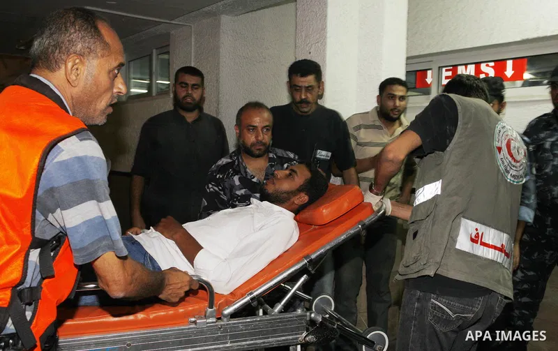 Palestinians wheel a wounded man following an Israeli attack in Gaza City on August 19, 2011. Photo by Mahmud Nassar