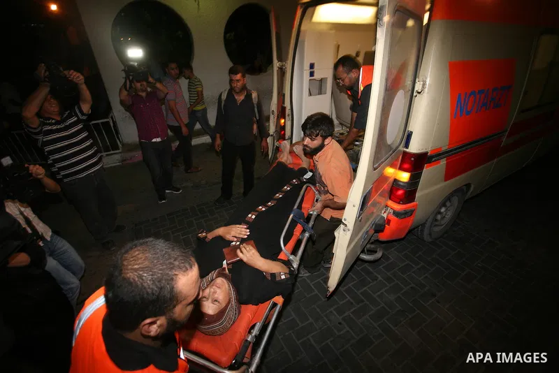 Palestinians wheel a wounded woman following an Israeli attack in Gaza City on August 19, 2011. Photo by Mahmud Nassar