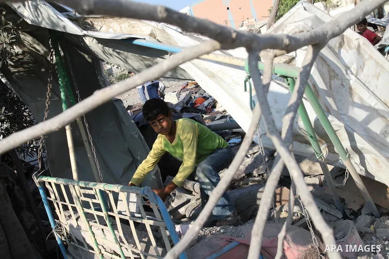 Palestinians stand over a destroyed house after an Israeli air strike in Gaza city August 19, 2011. Israeli aircraft struck Hamas security installations in Gaza on Friday, killing at least one Palestinian, in further ret...