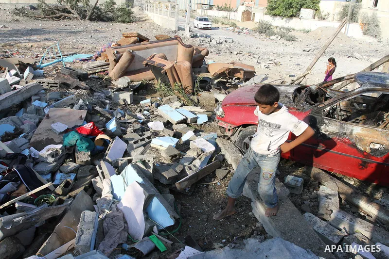Palestinians stand over a destroyed house after an Israeli air strike in Gaza city August 19, 2011. Israeli aircraft struck Hamas security installations in Gaza on Friday, killing at least one Palestinian, in further ret...