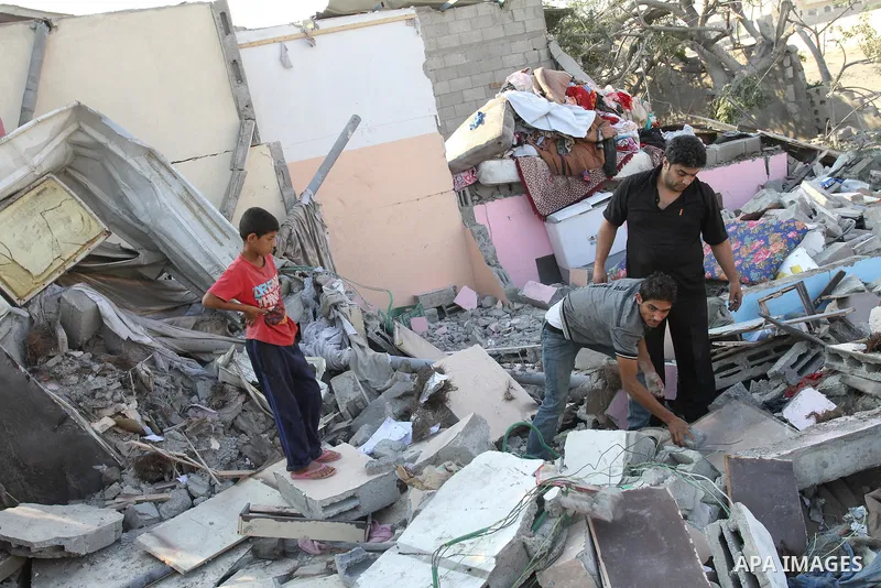 Palestinians stand over a destroyed house after an Israeli air strike in Gaza city August 19, 2011. Israeli aircraft struck Hamas security installations in Gaza on Friday, killing at least one Palestinian, in further ret...