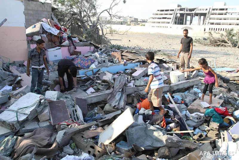Palestinians stand over a destroyed house after an Israeli air strike in Gaza city August 19, 2011. Israeli aircraft struck Hamas security installations in Gaza on Friday, killing at least one Palestinian, in further ret...