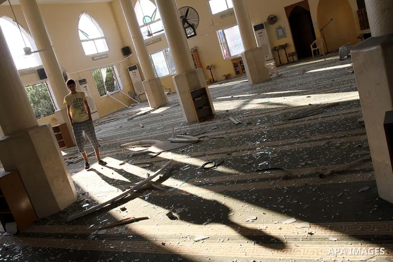 A Palestinian man surveys the damage in Bin Zayed mosque after an Israeli air strike in Gaza August 19, 2011. Israeli aircraft struck Hamas security installations in Gaza on Friday, killing at least one Palestinian, in f...