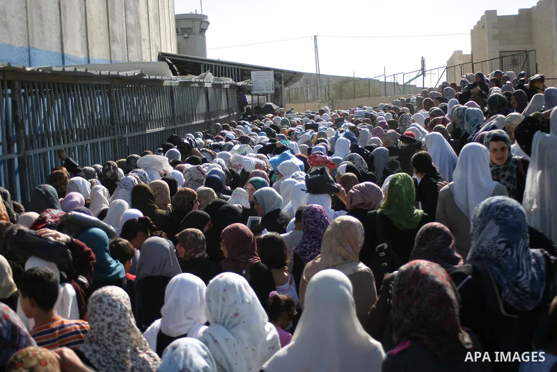 Palestinian Muslims wait at an Israeli checkpoint on the outskirts of the West Bank city of Bethlehem on August 19, 2011 as they wait to cross into Jerusalem to attend on their way to pray at the Al Aqsa Mosque on the th...