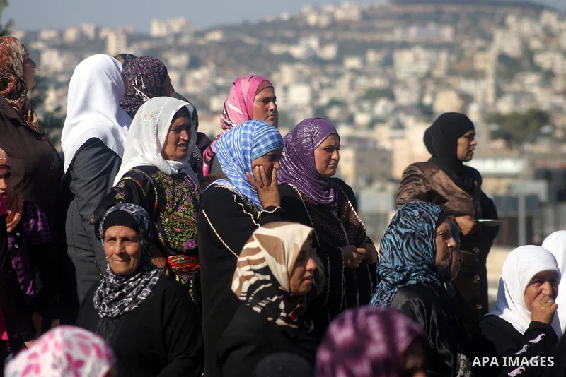 Palestinian Muslims wait at an Israeli checkpoint on the outskirts of the West Bank city of Bethlehem on August 19, 2011 as they wait to cross into Jerusalem to attend on their way to pray at the Al Aqsa Mosque on the th...