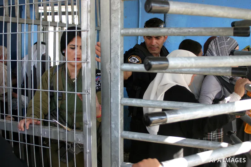Palestinian Muslims wait at an Israeli checkpoint on the outskirts of the West Bank city of Bethlehem on August 19, 2011 as they wait to cross into Jerusalem to attend on their way to pray at the Al Aqsa Mosque on the th...