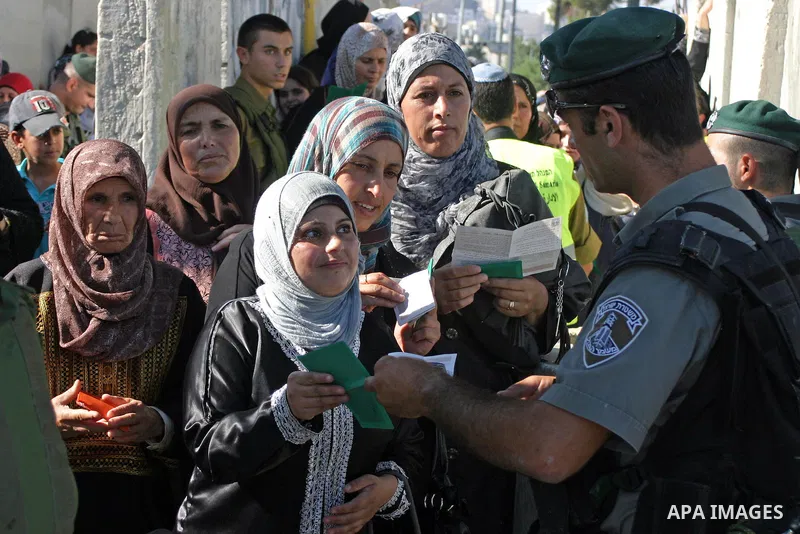 Palestinian Muslims wait at an Israeli checkpoint on the outskirts of the West Bank city of Bethlehem on August 19, 2011 as they wait to cross into Jerusalem to attend on their way to pray at the Al Aqsa Mosque on the th...