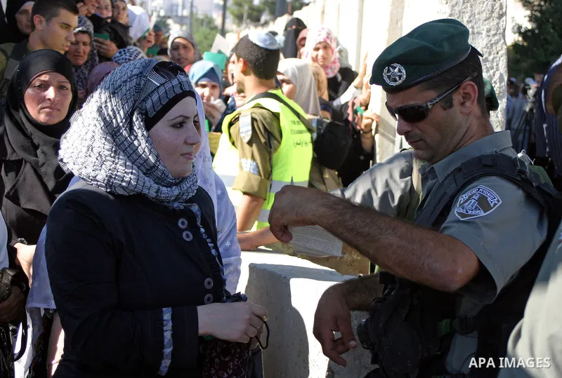 Palestinian Muslims wait at an Israeli checkpoint on the outskirts of the West Bank city of Bethlehem on August 19, 2011 as they wait to cross into Jerusalem to attend on their way to pray at the Al Aqsa Mosque on the th...