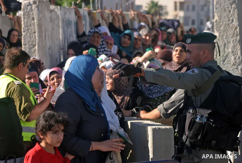 Palestinian Muslims wait at an Israeli checkpoint on the outskirts of the West Bank city of Bethlehem on August 19, 2011 as they wait to cross into Jerusalem to attend on their way to pray at the Al Aqsa Mosque on the th...