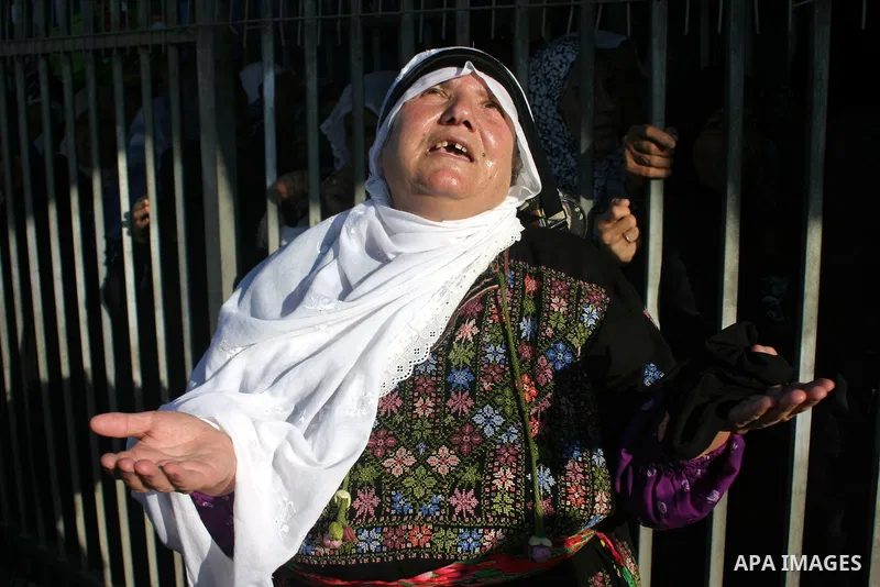 Palestinian Muslims walk through an Israeli checkpoint on the outskirts of the West Bank city of Bethlehem on August 19, 2011 as they wait to cross into Jerusalem to attend on their way to pray at the Al Aqsa Mosque on t...