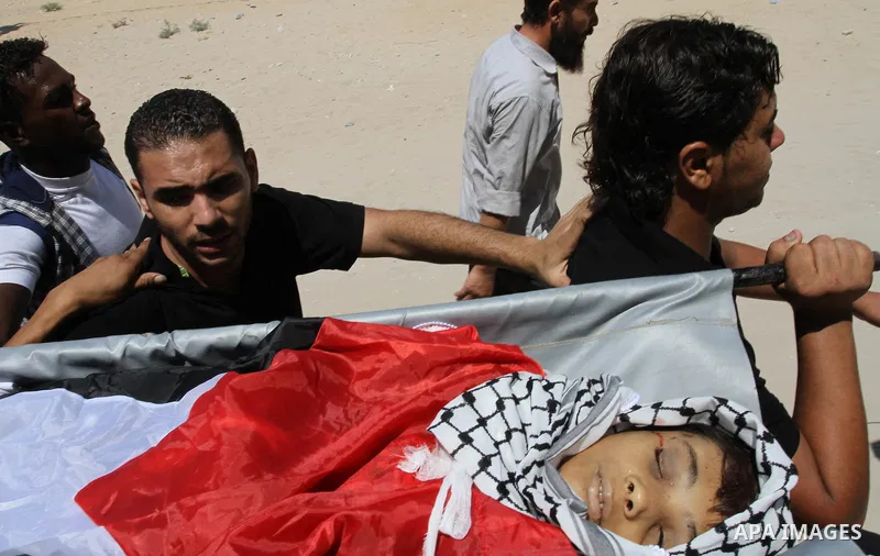 Palestinian mourners carry the body of Mahmoud Abu Samra, 13, killed in an Israeli airstrike early Friday, during his funeral in Gaza City, Aug. 19, 2011. Gaza militants launched barrages of rockets deep into Israel earl...