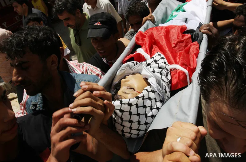 Palestinian mourners carry the body of Mahmoud Abu Samra, 13, killed in an Israeli airstrike early Friday, during his funeral in Gaza City, Aug. 19, 2011. Gaza militants launched barrages of rockets deep into Israel earl...